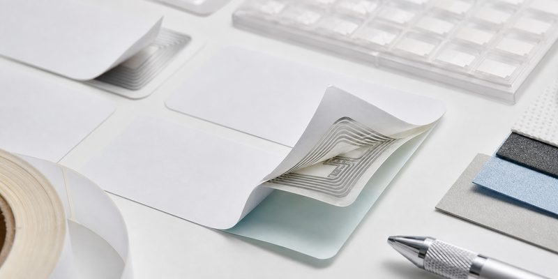 Layered RFID adhesive label showing face material inlay adhesive and liner